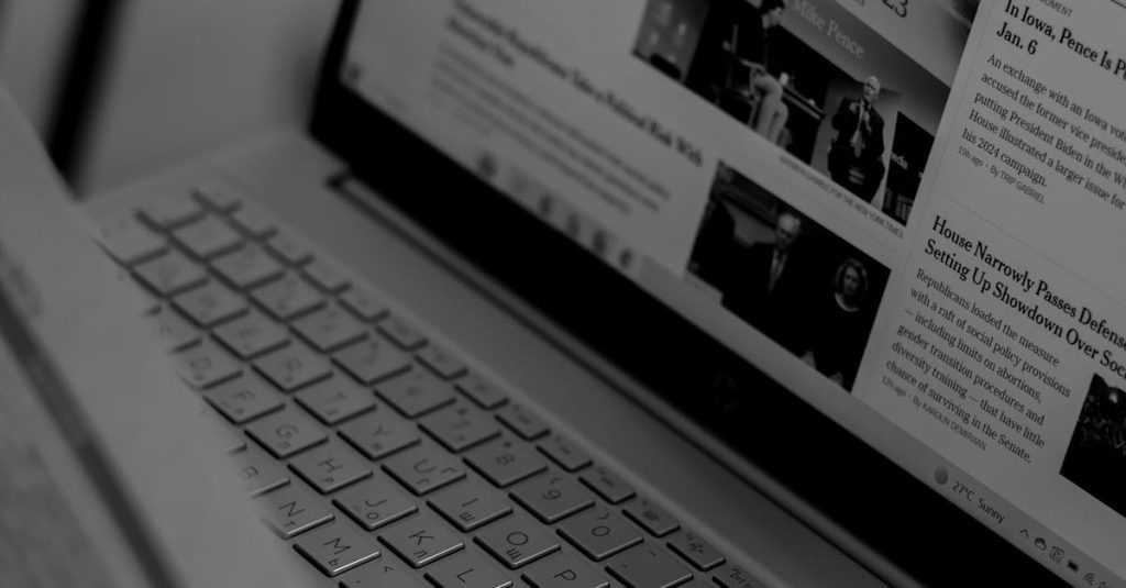 Black and white photo of a laptop showing a news website with focus on U.S. politics section.